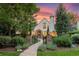 Charming Tudor-style home with stone walkway, manicured lawn, and mature landscaping at dusk at 5530 E 6Th Ave Pkwy, Denver, CO 80220