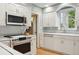 Updated kitchen with white cabinetry, stainless steel appliances, and a modern cooktop range at 5530 E 6Th Ave Pkwy, Denver, CO 80220
