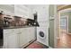 Convenient laundry room with white cabinets and a stacked washer and dryer at 5530 E 6Th Ave Pkwy, Denver, CO 80220