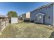 Backyard showcasing an expansive lawn area enclosed by a wooden fence and featuring a shed for extra storage at 9832 Kenton Cir, Commerce City, CO 80022