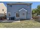 Wide backyard view of a home's back facade, patio, grill and fenced yard for privacy and outdoor enjoyment at 9832 Kenton Cir, Commerce City, CO 80022