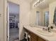 Bright bathroom featuring a vanity with sink and a mirror reflecting a glimpse into the bedroom at 9832 Kenton Cir, Commerce City, CO 80022