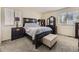 Well-lit primary bedroom featuring carpet, neutral walls, and stylish dark wood furniture at 9832 Kenton Cir, Commerce City, CO 80022