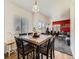Cozy dining area featuring a wooden table and chairs adjacent to the living room with natural light through the windows at 9832 Kenton Cir, Commerce City, CO 80022