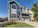 Charming two-story home boasts blue siding, stone accents, a manicured lawn, and an attached two-car garage at 9832 Kenton Cir, Commerce City, CO 80022