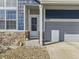 Charming two-story home boasts stone accents, a manicured lawn, and an attached two-car garage at 9832 Kenton Cir, Commerce City, CO 80022