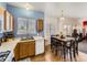 Open kitchen area with wooden cabinets, white appliances, a sink under the window, and a connected dining area at 9832 Kenton Cir, Commerce City, CO 80022