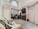Bright living room with tall windows, a fireplace, carpet, and a comfortable sofa at 9832 Kenton Cir, Commerce City, CO 80022