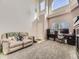 Bright living room featuring large windows, neutral carpet, a comfortable sofa, and a dedicated office space at 9832 Kenton Cir, Commerce City, CO 80022