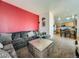 The expansive living room has a red accent wall, a gray sectional sofa, and an open layout into the kitchen at 9832 Kenton Cir, Commerce City, CO 80022