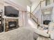 Cozy living room with a marble-surround fireplace, staircase, and dining room access at 9832 Kenton Cir, Commerce City, CO 80022