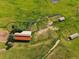 Aerial shot of multiple outbuildings and sheds with pastures in a rural setting at 5939 Lone Peak Dr, Evergreen, CO 80439