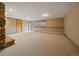 Large basement space featuring an exposed stone fireplace, neutral carpet, and walk out doors at 5939 Lone Peak Dr, Evergreen, CO 80439