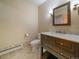 Well-lit bathroom featuring a modern vanity, a decorative mirror, and neutral wall paint at 5939 Lone Peak Dr, Evergreen, CO 80439