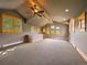 Spacious carpeted bonus room featuring vaulted ceilings, multiple windows, and ceiling fans at 5939 Lone Peak Dr, Evergreen, CO 80439