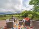 Outdoor deck overlooking mountain views, furnished with patio furniture and colorful rug at 5939 Lone Peak Dr, Evergreen, CO 80439