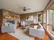 Inviting living room with a stone fireplace, ceiling fan and comfortable seating area by bright windows at 5939 Lone Peak Dr, Evergreen, CO 80439