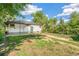 Green backyard featuring a charming house, patio, and a grassy yard space at 5008 Alcott St, Denver, CO 80221
