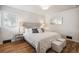 Bright bedroom with hardwood floors, a plush bed, and stylish bedside tables with a decorous mirror at 5008 Alcott St, Denver, CO 80221