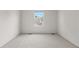 Minimalist bedroom featuring light carpet, a window, and freshly painted white walls at 4069 S Abilene Cir # E, Aurora, CO 80014