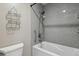 Close-up of a sparkling clean tub/shower combo with a shower rack and neutral-colored walls at 12622 E Warren Dr # E, Aurora, CO 80014