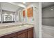 This bathroom features a wood vanity with tile countertop with a mirror and a shower and tub combo at 12622 E Warren Dr # E, Aurora, CO 80014