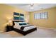 Comfortable bedroom with yellow walls, a ceiling fan and a window with blinds over a neatly made bed at 12622 E Warren Dr # E, Aurora, CO 80014