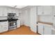 Bright kitchen features white cabinets, stainless steel appliances, and wood-style flooring at 12622 E Warren Dr # E, Aurora, CO 80014