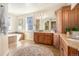 Spacious bathroom featuring a soaking tub, tiled floors, and wood cabinets at 2416 Fossil Trace Dr, Golden, CO 80401