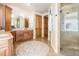 Well-lit bathroom with dual sink vanities, tiled flooring, and glass enclosed shower at 2416 Fossil Trace Dr, Golden, CO 80401