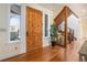 Inviting foyer featuring hardwood floors, a wooden staircase, and plenty of natural light at 2416 Fossil Trace Dr, Golden, CO 80401