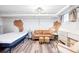 Cozy bedroom area featuring a bed, sofa, ottomans, and exposed brick accent wall at 1331 N Ogden St # 1, Denver, CO 80218