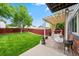 Outdoor patio area provides shade, a table with seating, and a hammock for relaxing in the backyard at 12545 Elm St, Thornton, CO 80241