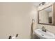 Clean half-bathroom featuring a modern sink, vanity mirror, and ample lighting at 12545 Elm St, Thornton, CO 80241