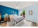 Bright and airy bedroom featuring a king-size bed, blue accent wall, and sliding glass door with backyard view at 12545 Elm St, Thornton, CO 80241