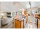 Well-lit kitchen featuring wooden cabinetry, granite countertops, stainless steel appliances, and an open view to the cozy living room at 12545 Elm St, Thornton, CO 80241