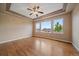Bright bedroom with wood flooring, tray ceiling, ceiling fan, and large windows at 22873 E David Pl, Aurora, CO 80016