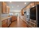 Open kitchen layout with wood cabinets, granite countertops, and stainless steel appliances at 22873 E David Pl, Aurora, CO 80016