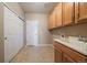 Spacious laundry room featuring tile flooring, cabinets, utility sink, and exterior access at 22873 E David Pl, Aurora, CO 80016