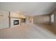 Spacious living room with a tiled fireplace, built-in shelving, and plush carpet at 22873 E David Pl, Aurora, CO 80016