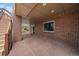 Spacious covered patio with stone flooring, brick columns, and steps leading to the yard at 22873 E David Pl, Aurora, CO 80016