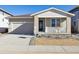 Charming single-story home with stone accents, front porch, neutral colors, attached garage, and landscaped front yard at 260 Lark Sparrow Way, Bennett, CO 80102