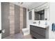 Modern bathroom featuring striped tile accent wall, sleek vanity, and minimalist fixtures at 3925 S Cherry St, Englewood, CO 80113