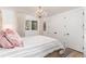 Bright bedroom with a decorative chandelier, striped accent rug, and white plank closet doors at 3925 S Cherry St, Englewood, CO 80113