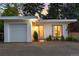 Home exterior features a garage and front door with lovely greenery at 3925 S Cherry St, Englewood, CO 80113