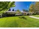 Well-maintained single-story home with lush green lawn, mature trees, and a welcoming walkway at 3925 S Cherry St, Englewood, CO 80113