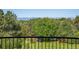 Lush landscaping view of large yard and trees from a balcony with black metal railing at 6616 E Prentice Ave, Greenwood Village, CO 80111