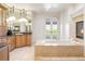 Spacious bathroom with a large tub, dual vanities, and a fireplace at 6616 E Prentice Ave, Greenwood Village, CO 80111