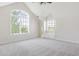 Spacious bedroom with a vaulted ceiling and large windows offering views of the surrounding greenery at 6616 E Prentice Ave, Greenwood Village, CO 80111
