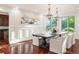 Beautiful dining room with hardwood floors, stylish chandeliers, and a bay window offering a scenic view at 6616 E Prentice Ave, Greenwood Village, CO 80111